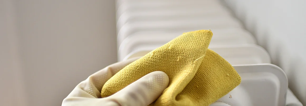 Hand in Handschuh reinigt Heizkörper